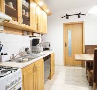 Küche in einer 3-Zimmer-Wohnung mit Holzschränken und Esstisch.