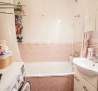 Badezimmer in einer 3-Zimmer-Wohnung mit Badewanne, Waschbecken, Waschmaschine und Stauraum.