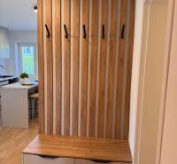 Flur in einer 2-Zimmer-Wohnung mit einer Lamellenwand und einer Kommode mit Stauraum.