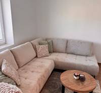 Ein bequemes helles Sofa und ein Tisch mit Dekoration in einer 2-Zimmer-Wohnung.