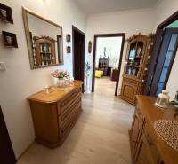 Innenraum einer 3-Zimmer-Wohnung mit Schränken, Dekorationen und einem Boden in Holzoptik.