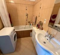 Badezimmer mit Dusche und Badewanne in einer 3-Zimmer-Wohnung, mit Waschmaschine und Waschbecken.