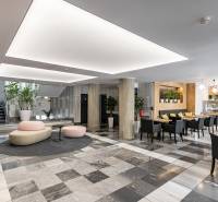 Büros mit schwarz-weißem Boden, Säulen, Sitzgelegenheiten und einem Café im Innenbereich.