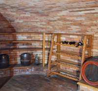 Weinkeller mit Ziegelwänden und Fässern in einem Einfamilienhaus.