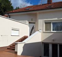 Ein Einfamilienhaus in Komárno mit weißer Fassade und rotem Dach.