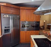 Küche in einem Einfamilienhaus mit Holzschränken und Edelstahlelektrogeräten.