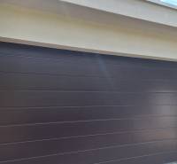 Garagentor bei einem Einfamilienhaus in Komárno, umgeben von Grün.