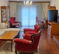 Wohnzimmer in einem Einfamilienhaus mit roten Sesseln und einem Boden in Holzoptik.