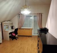 Ein Zimmer mit Holzboden, Möbeln und einem Kronleuchter in einem Einfamilienhaus.