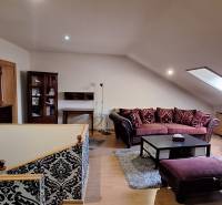 Wohnzimmer mit Sofas und gemusterten Wänden, Boden mit Holzdekor.