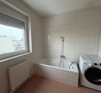 Badezimmer in einer 3-Zimmer-Wohnung mit Badewanne, Waschmaschine und großem Fenster.