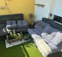 In der 3-Zimmer-Wohnung gibt es eine Terrasse mit Palettenmöbeln, Kissen und Pflanzen auf Kunstrasen.