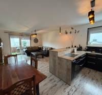 Wohnzimmer mit Küche in einer 3-Zimmer-Wohnung, Boden mit Holzdekor.