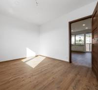 Ein Zimmer mit Holzboden und weißen Wänden in einer 3-Zimmer-Wohnung.