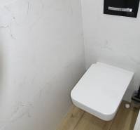 Badezimmer mit Toilette und Holzboden in einer 3-Zimmer-Wohnung.