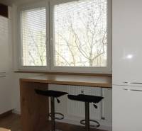 Küche einer 3-Zimmer-Wohnung mit Holzboden und großen Fenstern.