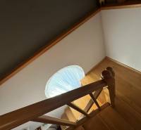 Eine Treppe mit Holzdekor in einem Einfamilienhaus mit Treppengeländer und rundem Fenster.