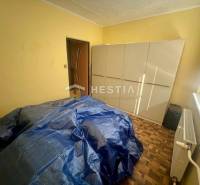 Ein Zimmer mit einem Schrank, einem Heizkörper und abgedeckten Möbeln in einer 3-Zimmer-Wohnung.