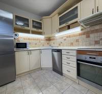 Küche in einer 2-Zimmer-Wohnung mit Geschirrspüler, Backofen, Mikrowelle und Fliesenverkleidung.