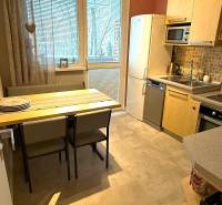 Küche in einer 3-Zimmer-Wohnung mit Esstisch, hellen Schränken und Kühlschrank.