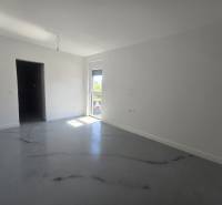 Ein geräumiges Zimmer in der Villa mit weißen Wänden und einem Boden in Holzoptik.