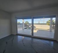 Innenraum der Villa mit großen Verglasungen und Blick auf den Außenbereich mit Pool.