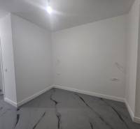 Prázdny Raum in einer Villa mit weißen Wänden und einem Boden mit Marmordekor.