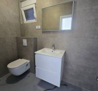 Badezimmer in der Villa mit modernem Waschbecken, hängendem WC und Spiegel an der Wand.