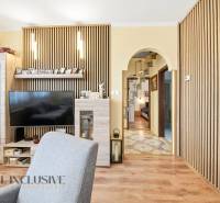 Wohnzimmer in einem Einfamilienhaus mit Fernseher und Boden in Holzoptik.