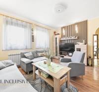 Wohnzimmer in einem Einfamilienhaus mit Sofa, Tisch, Fernseher und Holzboden.