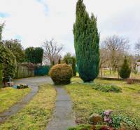 Der Garten des Einfamilienhauses in der Kalinčiaka-Straße in Michalovce mit Gehweg und Bäumen.