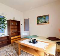 Wohnzimmer in einem Einfamilienhaus mit Teppichboden, Holzmöbeln und einem Strandbild.