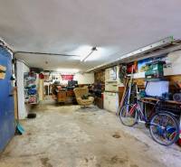 Garage in einem Einfamilienhaus mit Werkzeug, Fahrrad und Arbeitstisch.