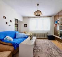 Wohnzimmer in einem Einfamilienhaus mit Teppichmuster und Wohnwand.