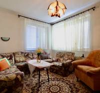 Wohnzimmer in einem Einfamilienhaus mit bequemen Polstermöbeln und dekorativem Teppich.