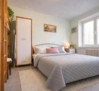 Schlafzimmer in einer 2-Zimmer-Wohnung mit großem Bett, Dekorationen und natürlicher Beleuchtung.