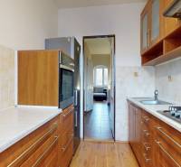 Küche in einer 3-Zimmer-Wohnung mit Holzboden und hellen Fliesen.