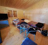 Ein Zimmer mit Wänden aus Holz, Betten, einem Fernseher und einem Boden mit Holzdekor.