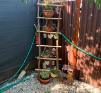 Gärten in Dolné Krškany in Nitra mit einer dekorativen Leiter und Blumentöpfen auf einem Kiesuntergrund.