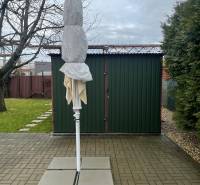 Gärten in Dolné Krškany in Nitra mit einem zusammengefalteten Sonnenschirm, befestigter Fläche und Rasen.