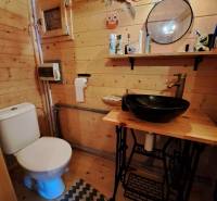 Holzinterieur eines Badezimmers mit Spiegel, Regal und Waschbecken in den Gärten.