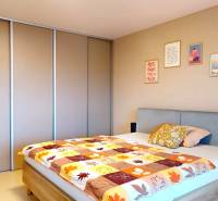 Schlafzimmer in einem Einfamilienhaus mit Bett, Einbauschrank und dekorativen Bildern an der Wand.