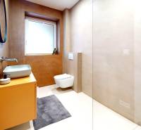 Badezimmer eines Einfamilienhauses mit Waschbecken, Spiegel und hängender Toilette in sanften Tönen.