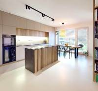 Offene Küche mit Esstisch und Bücherregal in einem Einfamilienhaus.