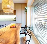 Küche in einem Einfamilienhaus mit einem massiven Tisch und einer Hängelampe.