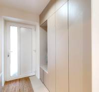 Eingangsflur eines Einfamilienhauses mit einem Garderobenschrank, einem Spiegel und einem Teppich.