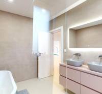 Badezimmer mit Badewanne, zwei Waschbecken und einem Spiegel in einem Einfamilienhaus.