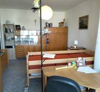 Ein Zimmer in einer 2-Zimmer-Wohnung mit Möbeln, einem Bett und Dekorationen auf den Regalen.