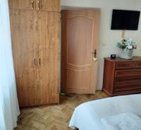 Schlafzimmer in einer 2-Zimmer-Wohnung mit Holzboden, Schrank und Fernseher.