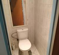 Badezimmer mit Fliesen und Toilette in einer 2-Zimmer-Wohnung.